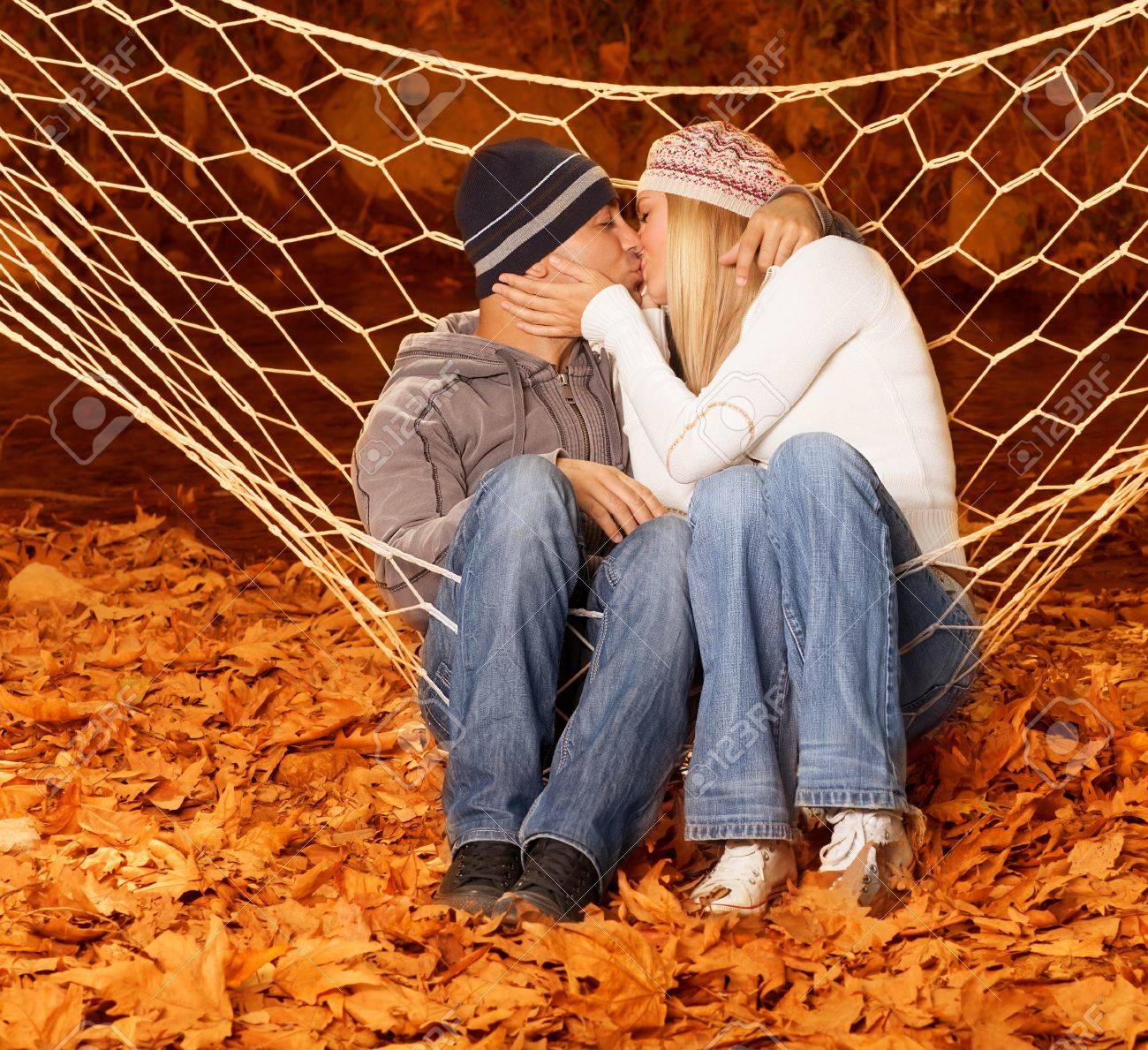 愛情のあるペア ハンモックのスイングとキス ロマンチックな関係は 幸せな家族の概念 妻と夫のハグ秋公園 美しい秋のシーズン 足の下のオレンジ色の紅葉の 画像 の写真素材 画像素材 Image