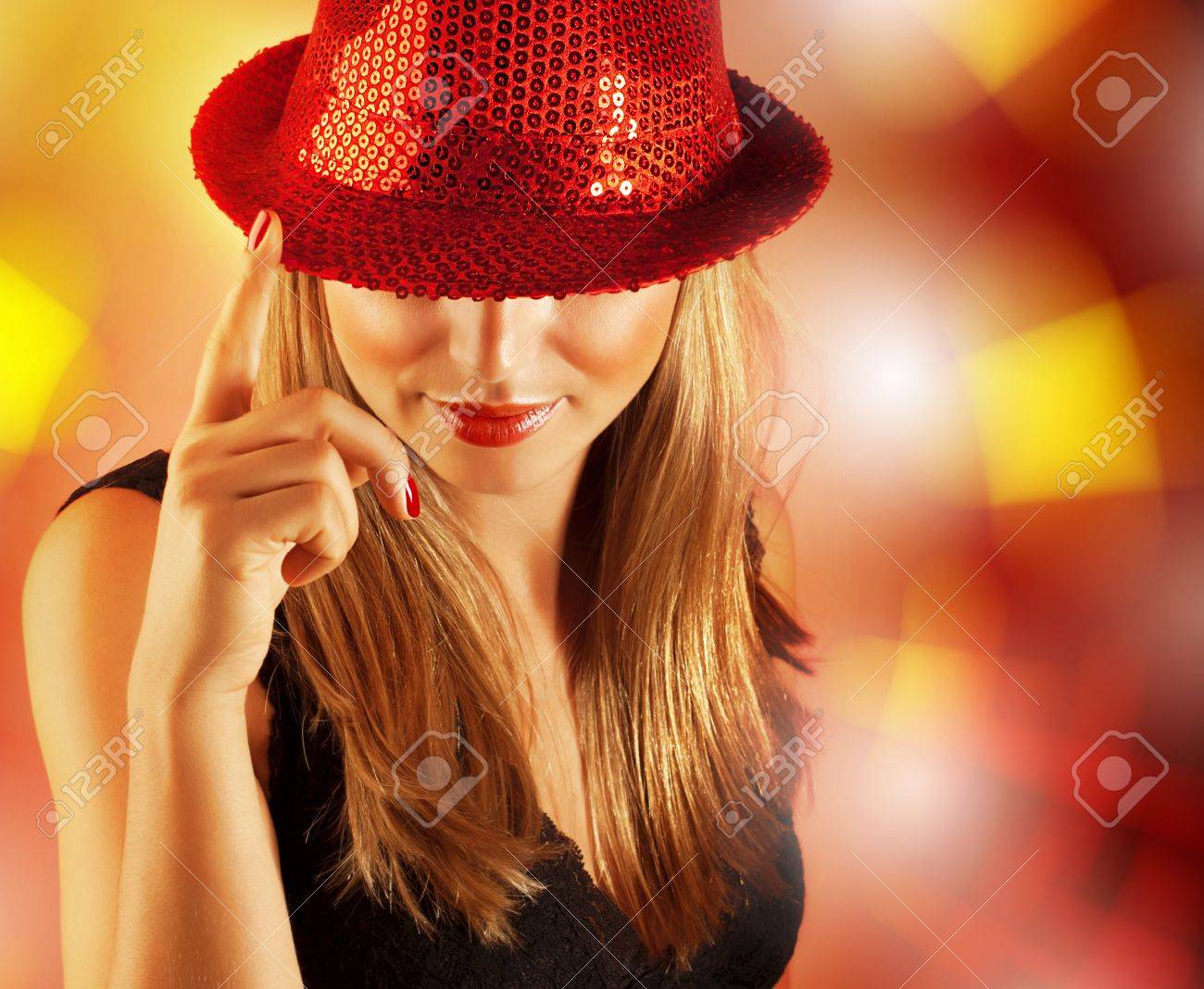 ぼかしの背景 彼女の目は 新年のお祝いのナイトクラブで音楽を楽しむ豪華なダンサーをカバーした赤い帽子身に着けているきれいな女性のクローズ アップの肖像画に分離された高級の歌手の女の子の画像 の写真素材 画像素材 Image