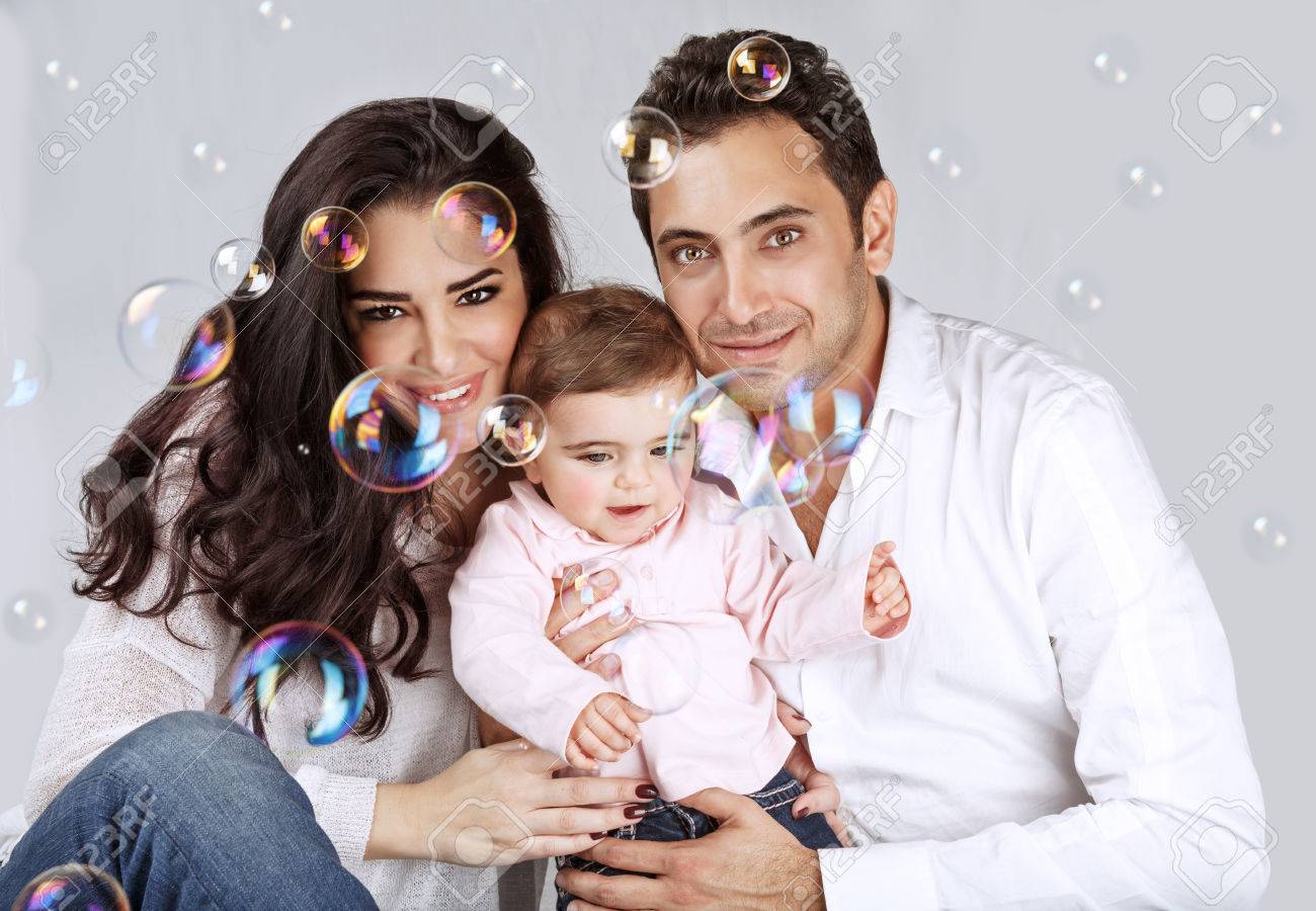 Portrait Of Cute Arabic Baby Girl With Mother And Father Playing