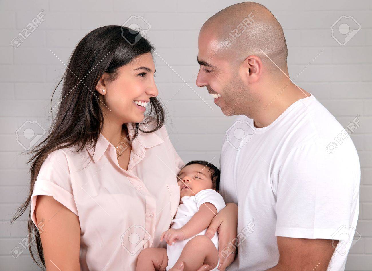 手かわいい生まれたばかりの娘 健康な子供 幸せな親子関係概念を保持している陽気な若い親の肖像画 の写真素材 画像素材 Image