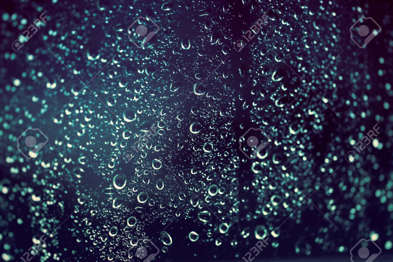 rainy background rain drops on the window at night autumn season