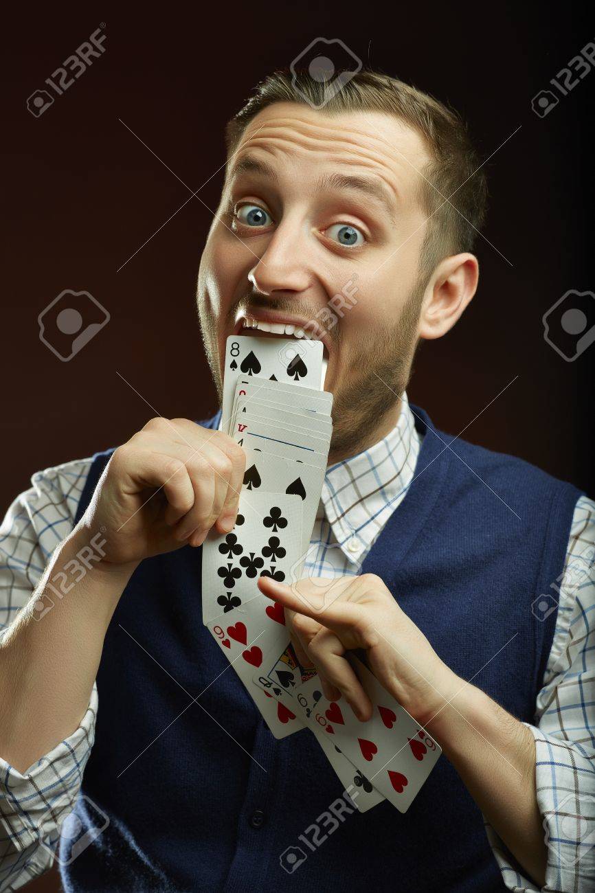 うれしそうな面白い男性の魔術師彼の口からトランプのシリーズ暗い背景の上 の写真素材 画像素材 Image