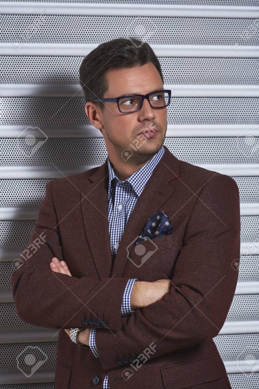 自信のめがね ハンサムな紳士組んだ腕でポーズをスタイリッシュなチェック シャツとグレーの金属上のポケットにはハンカチで茶色のスーツ ジャケット テクスチャ背景 の写真素材 画像素材 Image