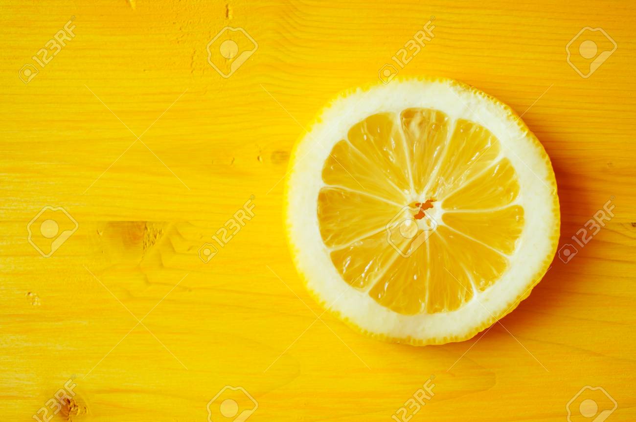 lemon slice on a yellow table closeup top view