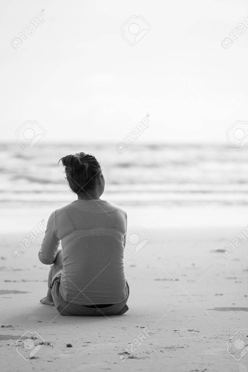 a cute girl sitting alone on a beach lonely heartbroken woman