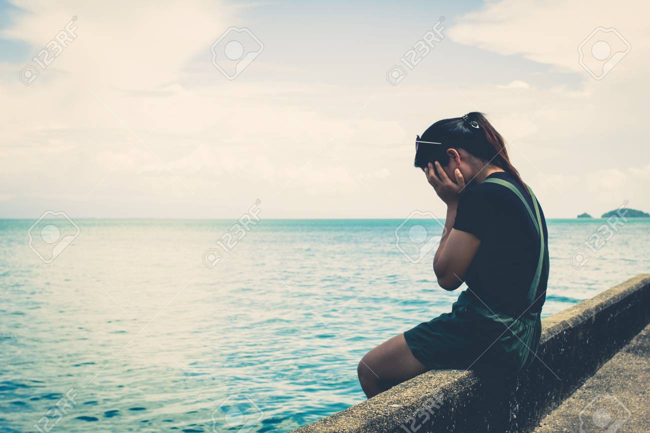 the girl sitting alone at the sea stock photo picture and royalty