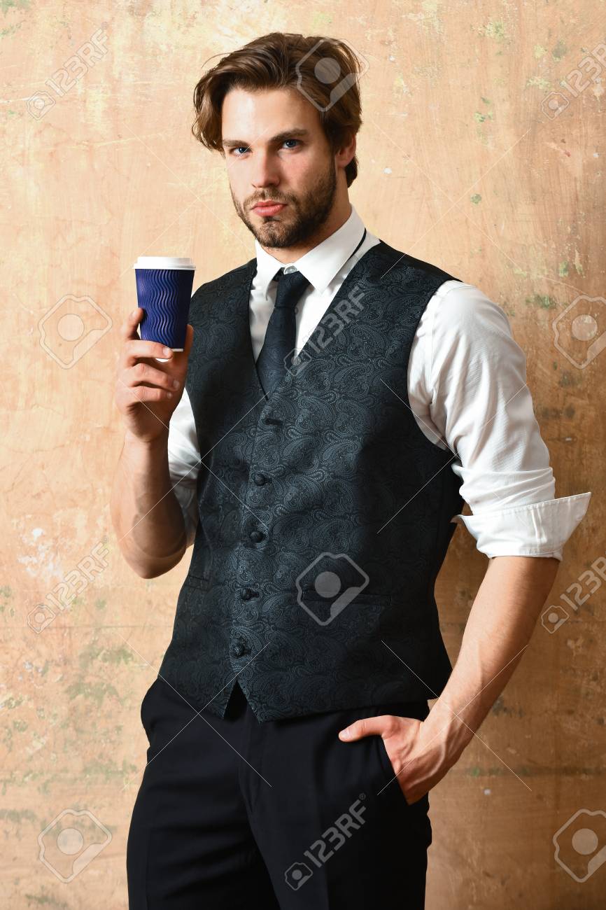 ベージュ色の背景にビジネス スーツで手にコーヒー紙コップを持つ男 の写真素材 画像素材 Image
