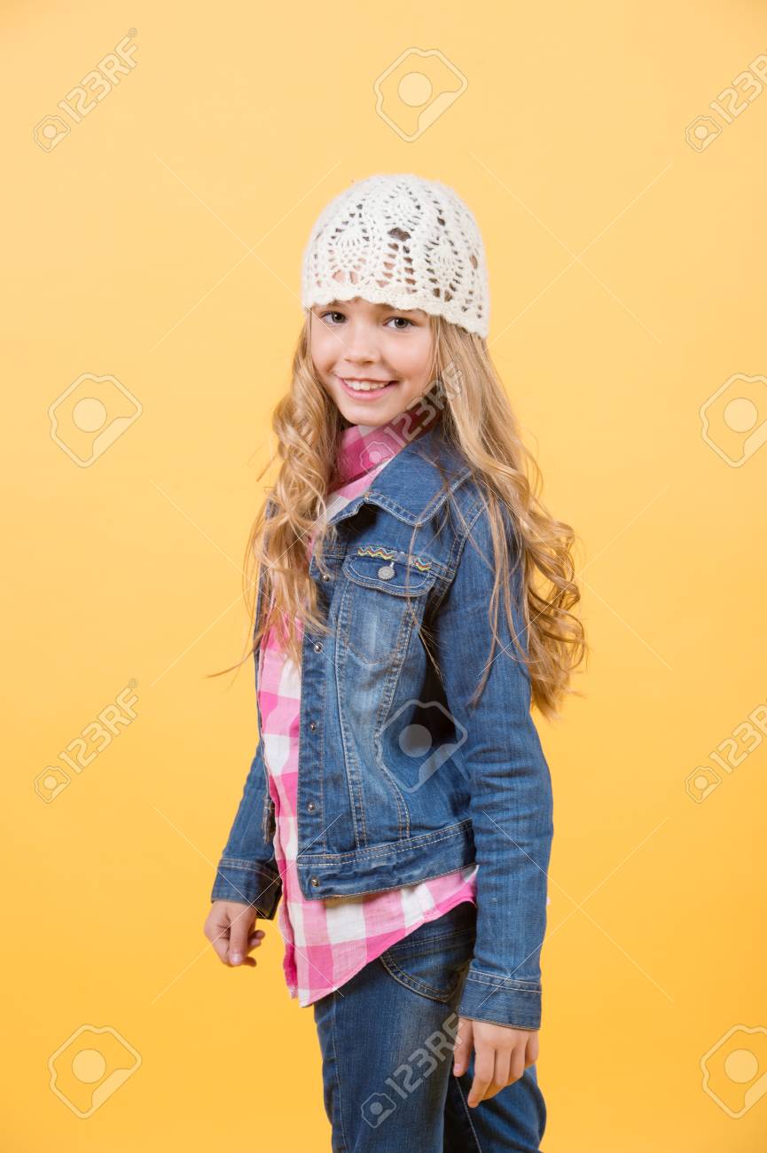 ジーンズのスーツ 帽子 オレンジ色の背景に格子縞のシャツの女の子 幸せな子供時代のコンセプトです 子供は 長いブロンドの髪と笑顔します 美しさ 表情 髪型 ファッション スタイル トレンド の写真素材 画像素材 Image