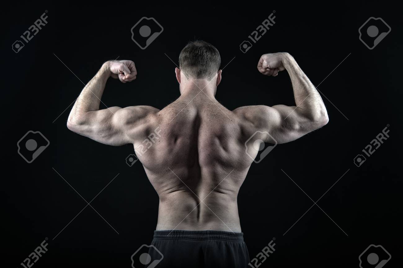 ダイエットとフィットネス 健康 スポーツとワークアウト 裸の胸を持つコーチスポーツマン 黒い背景に隔離されたズボンで運動ボディビルダーポーズ 筋肉質 の体 背中 二頭筋を持つ男 の写真素材 画像素材 Image