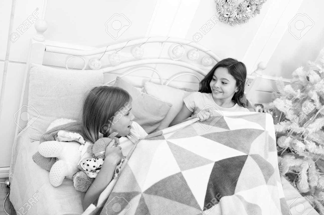 Christmas Eve. Sisters Sharing Toys. Sisters Best Friends. Kids Play Toys  In Bed. Little Girls Spend Time Together. Friendship Personal Relations.  Toys Shop. Cute Soft Toys. Happy Childhood Stock Photo, Picture and