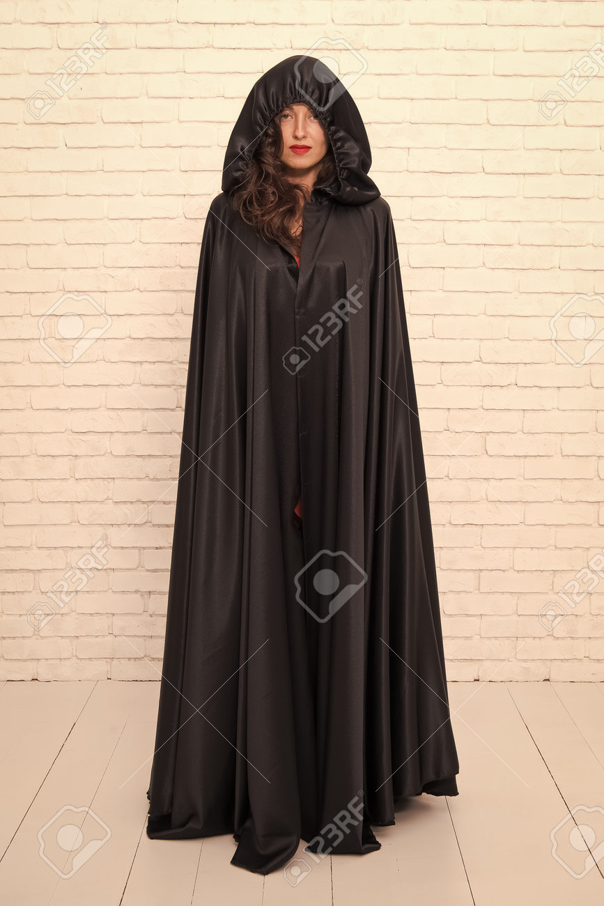 アダルトマント マントで覆われた少女。悪魔の概念。ハロウィーンの仮面舞踏会。ハロウィーンパーティー。くそーきれいな女性の悪魔。黒マントのシンボルの死。マントのセクシーな悪魔の女の子の吸血鬼。吸血鬼の悪魔を誘惑する女性の写真素材・画像素材  Image 169422391