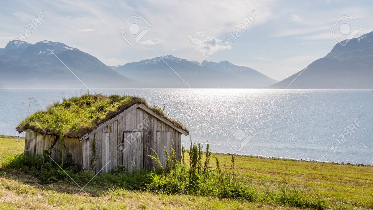 Typical Scandinavian landscape with an old hut with a green roof along a lake - 64630602 Typical Scandinavian landscape with an old hut with a green roof along a lake - 64630602