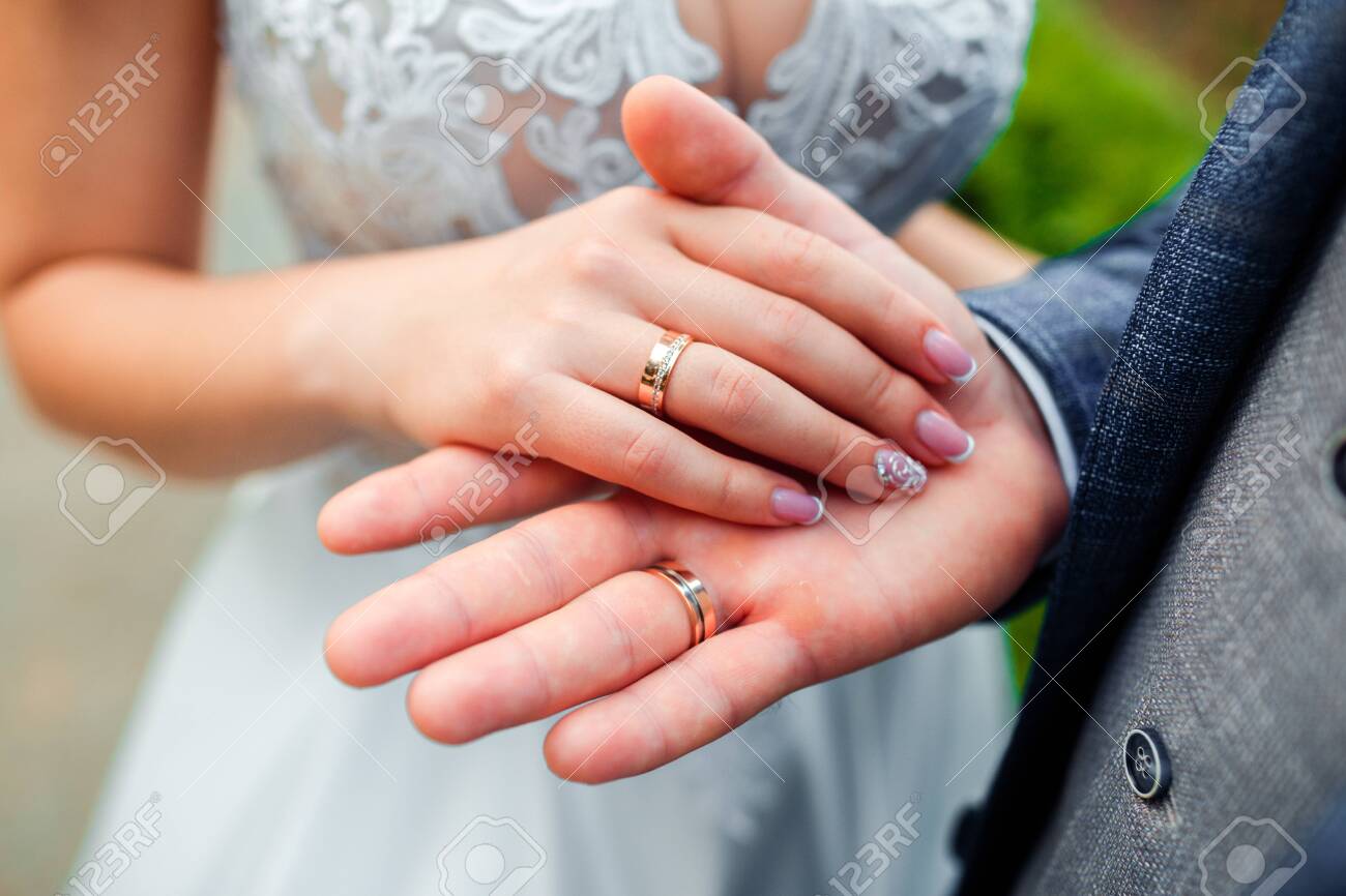 Wedding rings in the hands of the bride and groom. - 130020505 Wedding rings in the hands of the bride and groom. - 130020505