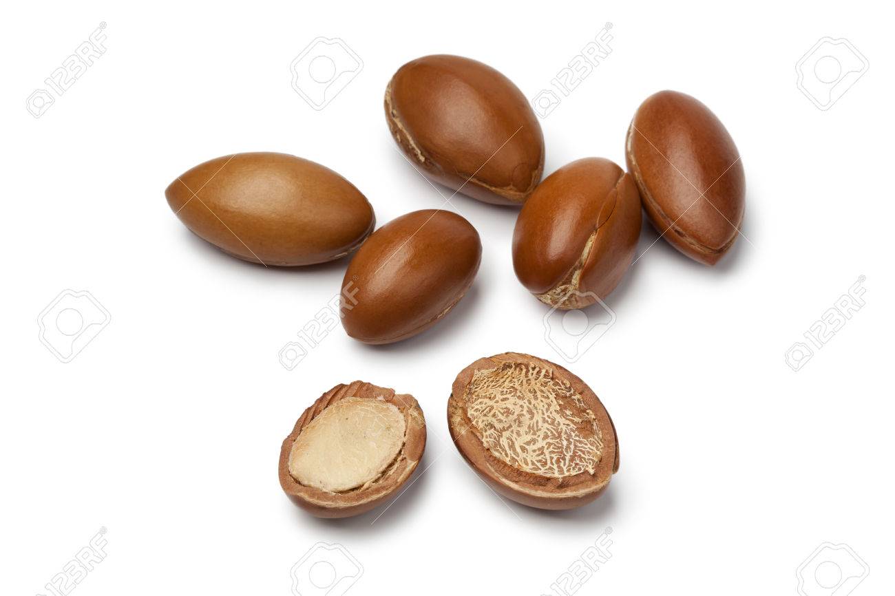 Whole and half Moroccan Argan nuts on white background - 23215288 Whole and half Moroccan Argan nuts on white background - 23215288