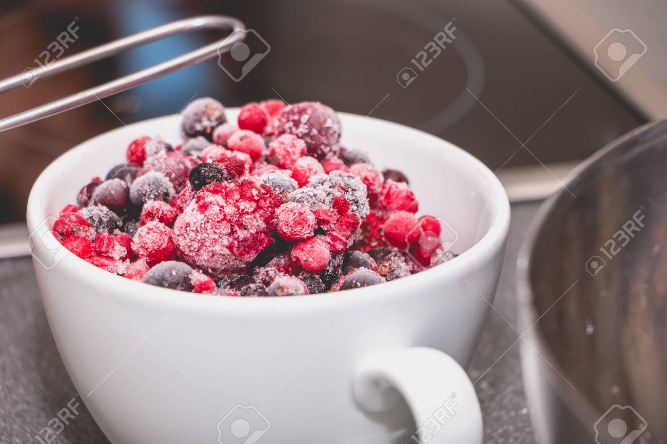 Schüssel Gefrorene Rote Frucht Auf Einer Arbeitsplatte In Einer ... Schüssel Gefrorene Rote Frucht Auf Einer Arbeitsplatte In Einer ...