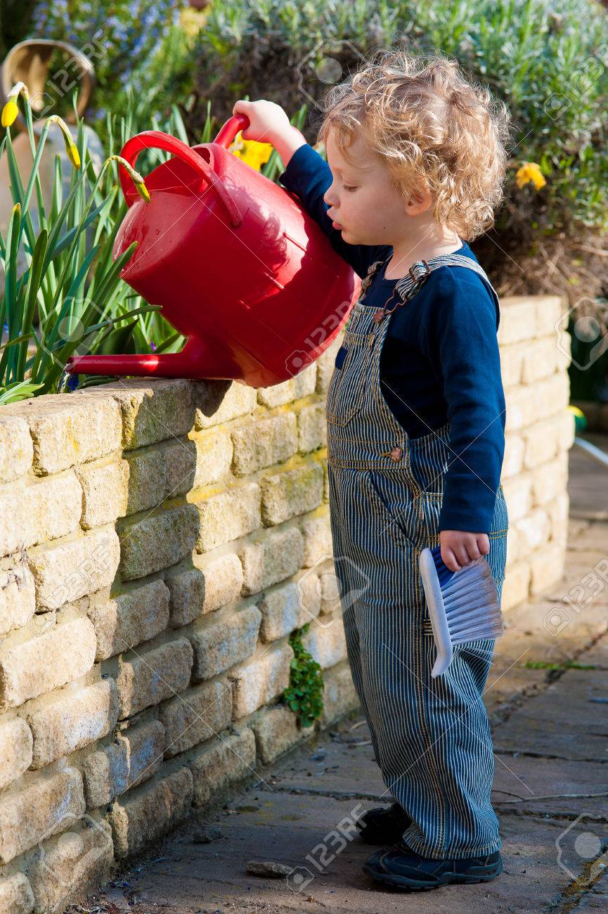 金髪のかわいいやんちゃな男の子の水の庭 の写真素材 画像素材 Image