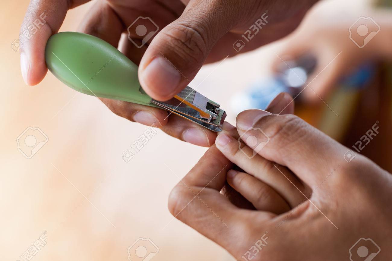Père Couper Les Ongles Pour Son Bébé Sur Table En Bois Fond