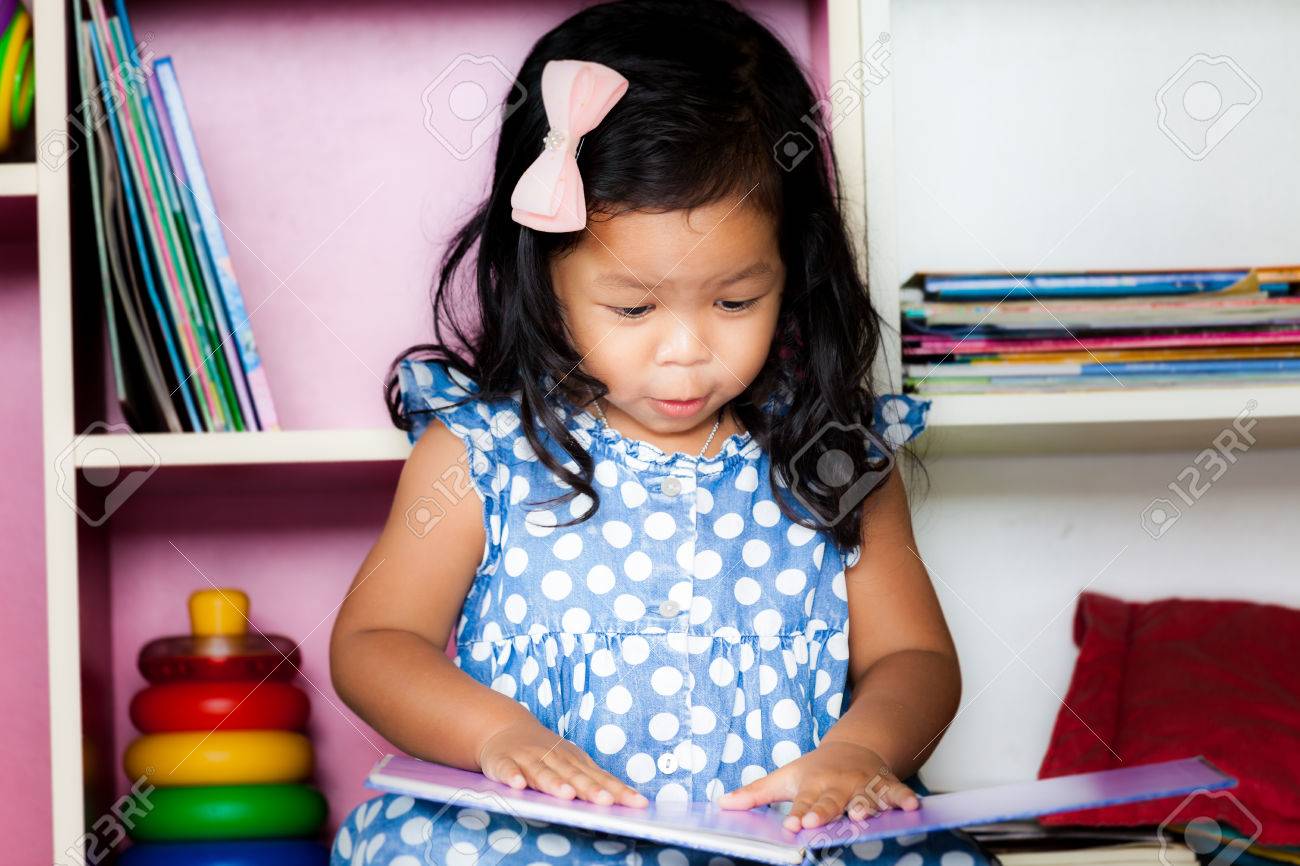 本棚の背景に本を読んでかわいい女の子を読む子 の写真素材 画像素材 Image