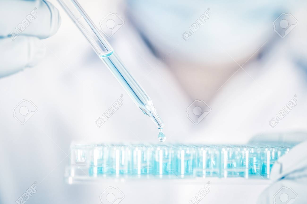 Close up a scientist working in laboratory to analyze blue extracted of DNA molecules in micro tube plate , clinical or science testing analysis concept - 96684337 Close up a scientist working in laboratory to analyze blue extracted of DNA molecules in micro tube plate , clinical or science testing analysis concept - 96684337