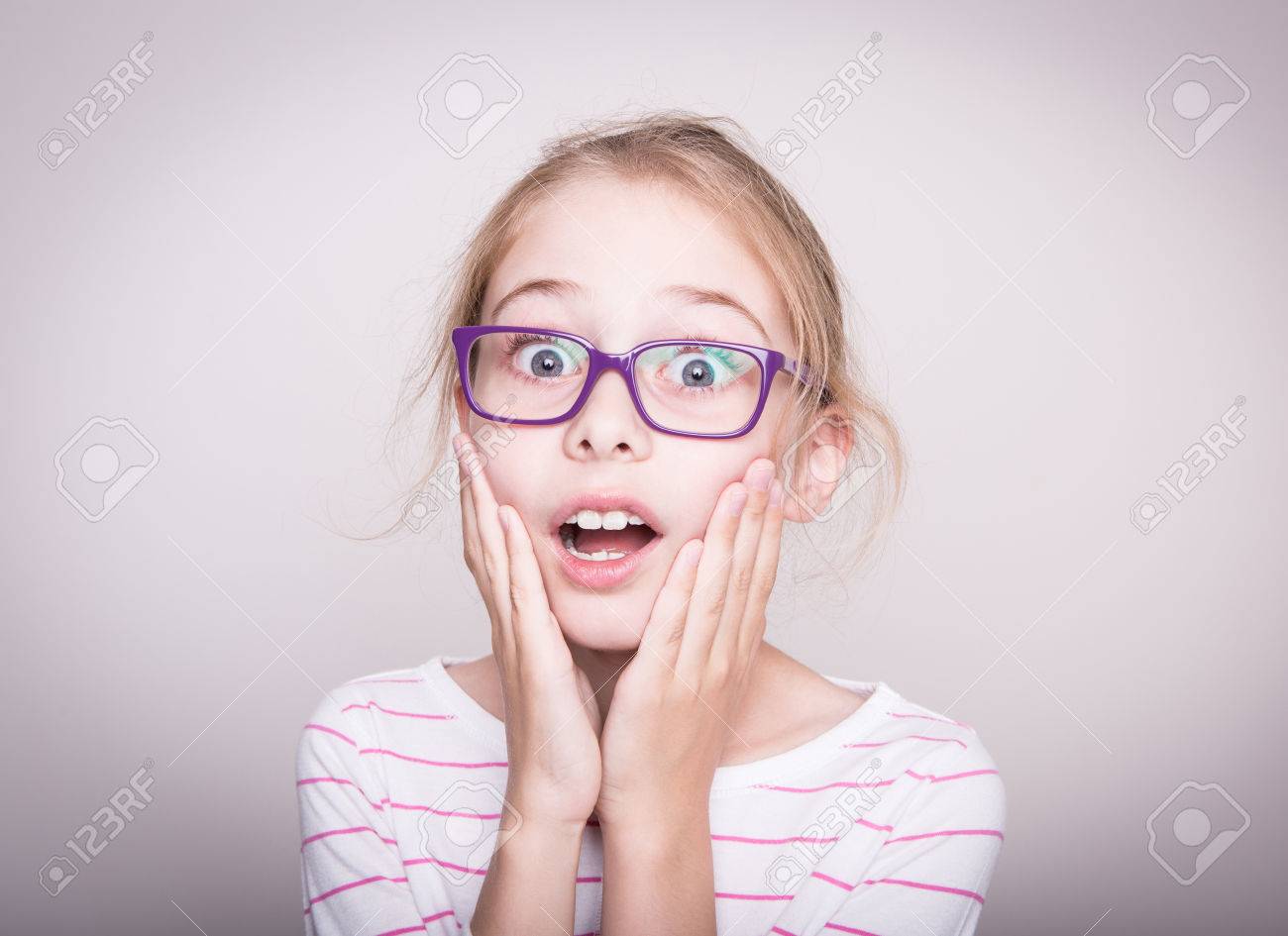 Surprised or shocked face of eight years old pretty blond caucasian child girl in violet glasses. Shock - facial expression. Layout with free copy space. - 61728559 Surprised or shocked face of eight years old pretty blond caucasian child girl in violet glasses. Shock - facial expression. Layout with free copy space. - 61728559