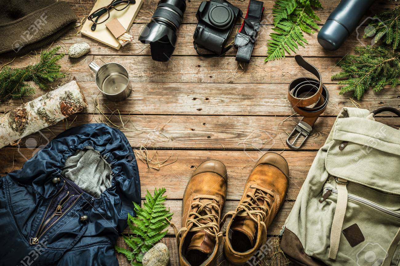 Camping or adventure trip scenery concept. Backpack, jacket, boots, belt, camera on wooden background captured from above (flat lay). Layout with free text (copy) space. - 86944926 Camping or adventure trip scenery concept. Backpack, jacket, boots, belt, camera on wooden background captured from above (flat lay). Layout with free text (copy) space. - 86944926