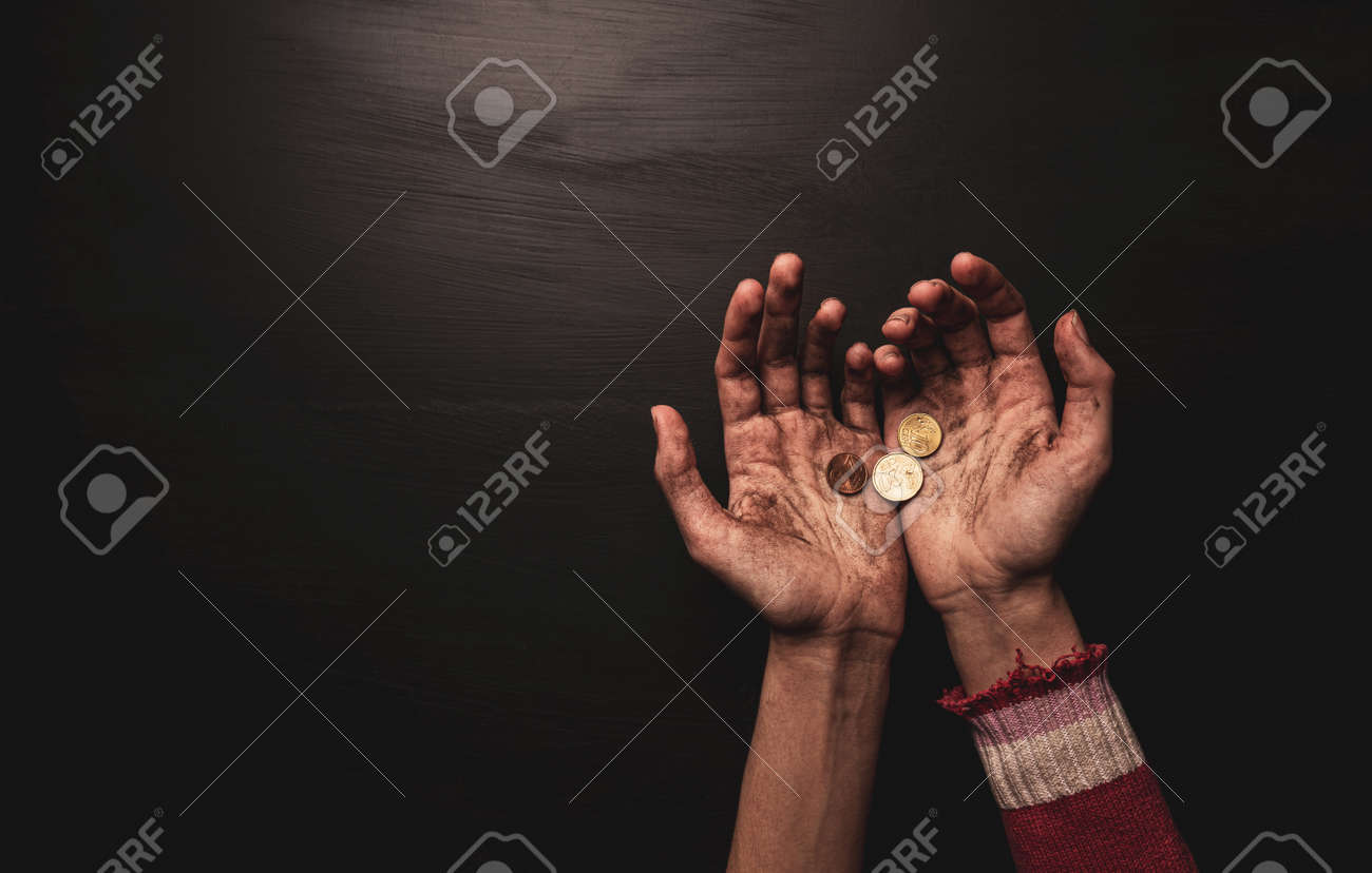 貧困-お金を物乞いする子供。黒の背景にコインで汚れた細い乞食の子供の手。フリーコピー（テキスト）スペースのあるレイアウト。上からキャプチャ（上面図）。の写真素材・画像素材  Image 182320859
