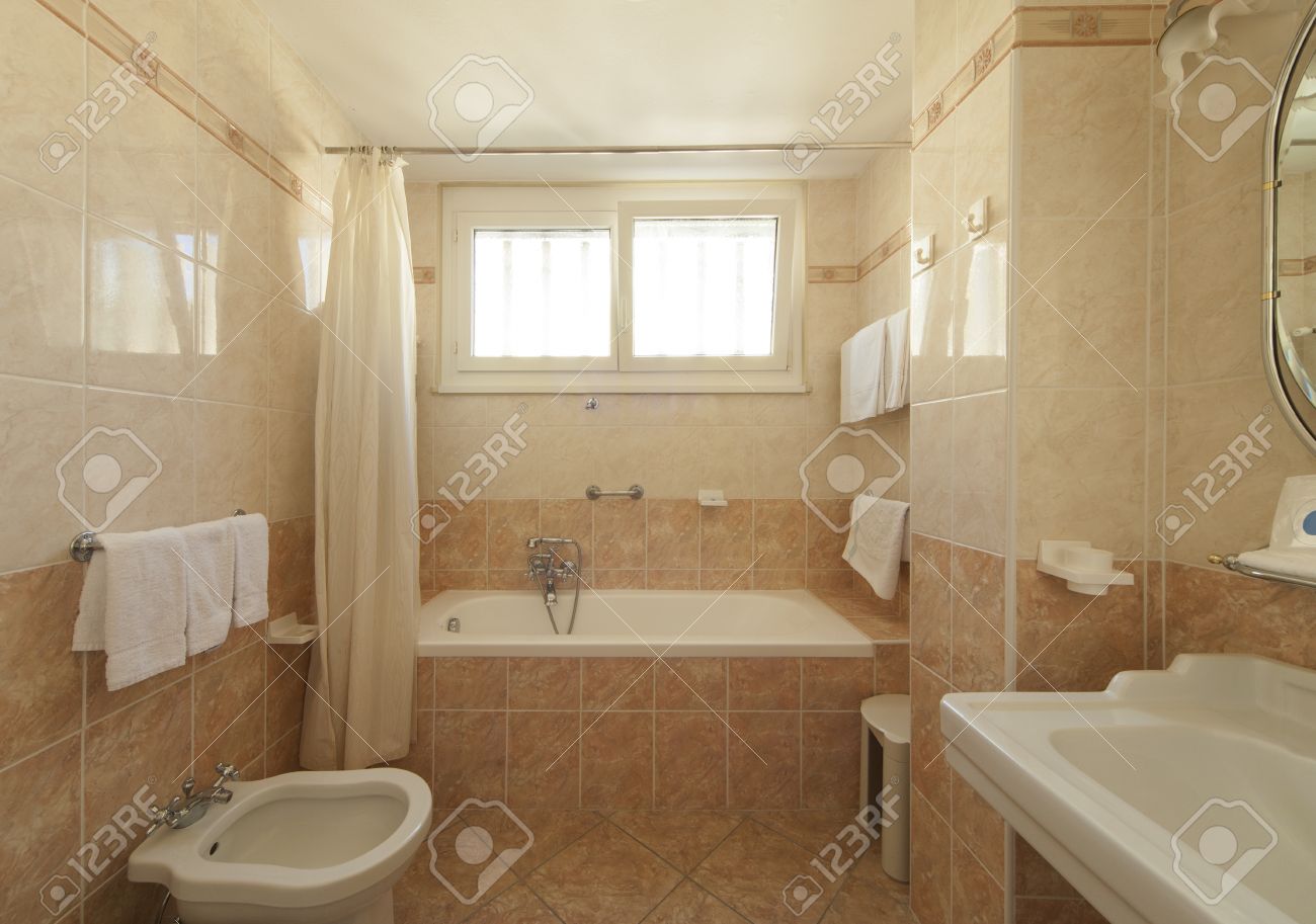 archivio fotografico bagno con piastrelle beige e decorazioni