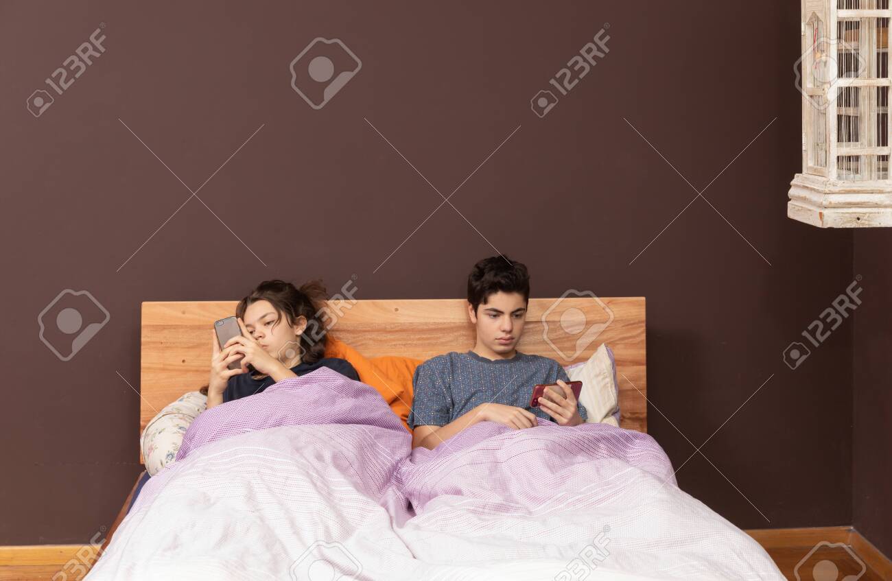 Brother And Sister In The Same Bed Chatting With Phone Stock Photo, Picture  and Royalty Free Image. Image 151808074.