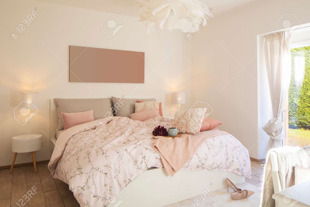 Modern, bright and luxury bedroom in design apartament. Fresh bed sheets and pillows above. There's a tray with a cup for breakfast. - 163075630 Modern, bright and luxury bedroom in design apartament. Fresh bed sheets and pillows above. There's a tray with a cup for breakfast. - 163075630