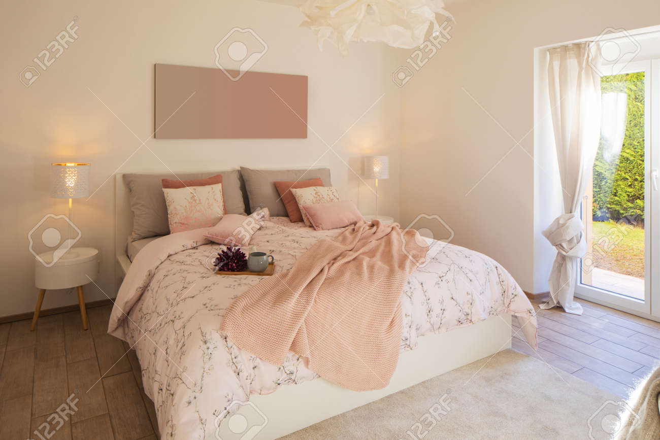Modern, bright and luxury bedroom in design apartament. Fresh bed sheets and pillows above. There's a tray with a cup for breakfast. - 163078106 Modern, bright and luxury bedroom in design apartament. Fresh bed sheets and pillows above. There's a tray with a cup for breakfast. - 163078106