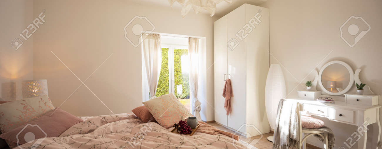 Modern, bright and luxury bedroom in design apartament. Fresh bed sheets and pillows above. There's a tray with a cup for breakfast. - 163078117 Modern, bright and luxury bedroom in design apartament. Fresh bed sheets and pillows above. There's a tray with a cup for breakfast. - 163078117