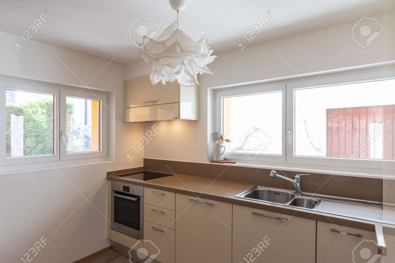 Clean and modern cream kitchen with large and bright windows. Nobody inside - 163079134 Clean and modern cream kitchen with large and bright windows. Nobody inside - 163079134