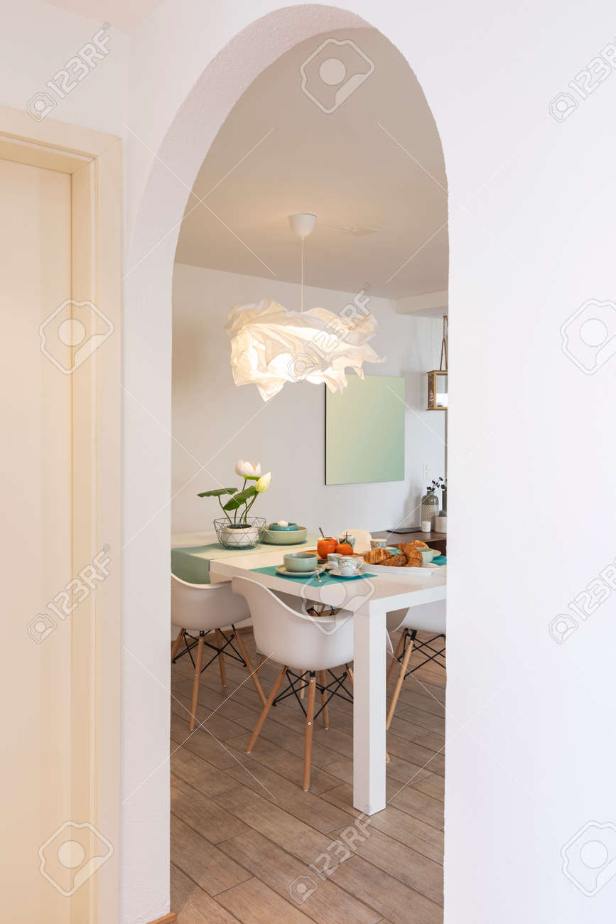 Detail from hallway of elegant and romantic white table ready for breakfast with brioche, cups for coffee and fruits. Nobody inside - 163079139 Detail from hallway of elegant and romantic white table ready for breakfast with brioche, cups for coffee and fruits. Nobody inside - 163079139