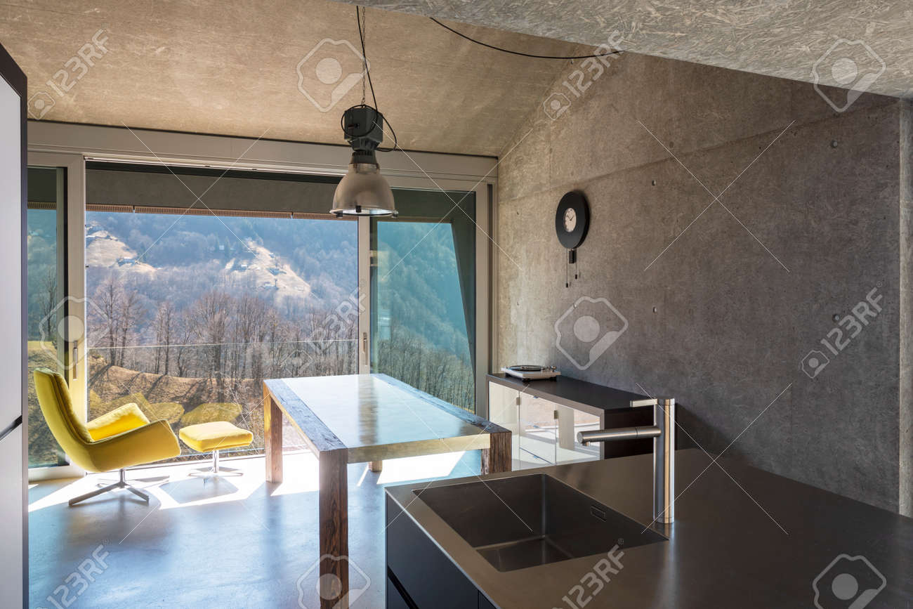 Detail of modern kitchen island, sink. Interior of a beautiful modern house, with a table, a yellow armchair and a view of nature. Nobody inside - 166417757 Detail of modern kitchen island, sink. Interior of a beautiful modern house, with a table, a yellow armchair and a view of nature. Nobody inside - 166417757