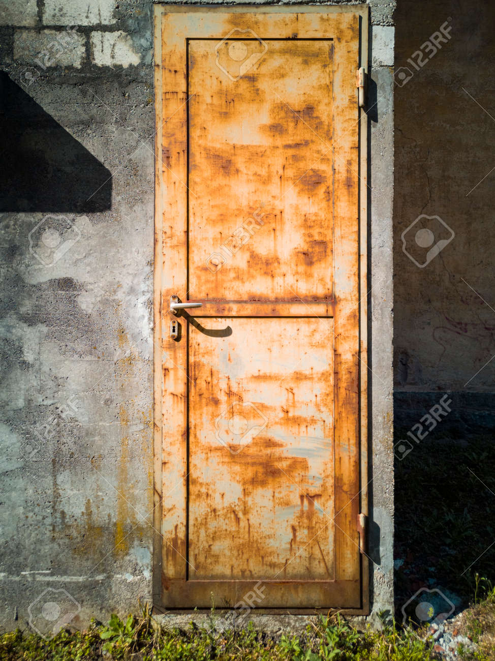 Detail of a rusty door of a factory. Frontal view. Nobody inside. Copy space - 170380109 Detail of a rusty door of a factory. Frontal view. Nobody inside. Copy space - 170380109