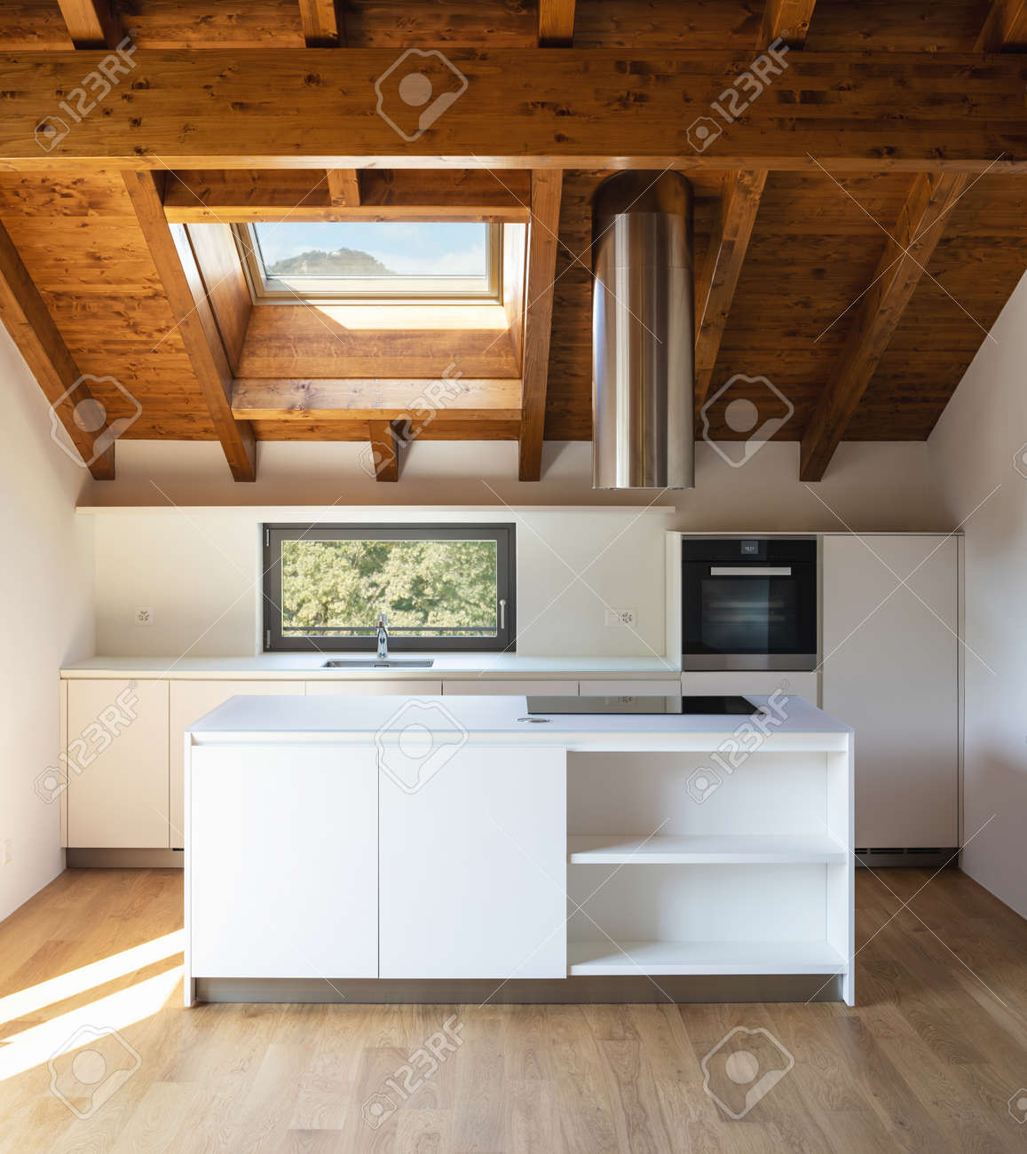 Front view white modern kitchen with island, steel hood and oven. Small window with views of nature. Nobody inside. - 167299059 Front view white modern kitchen with island, steel hood and oven. Small window with views of nature. Nobody inside. - 167299059