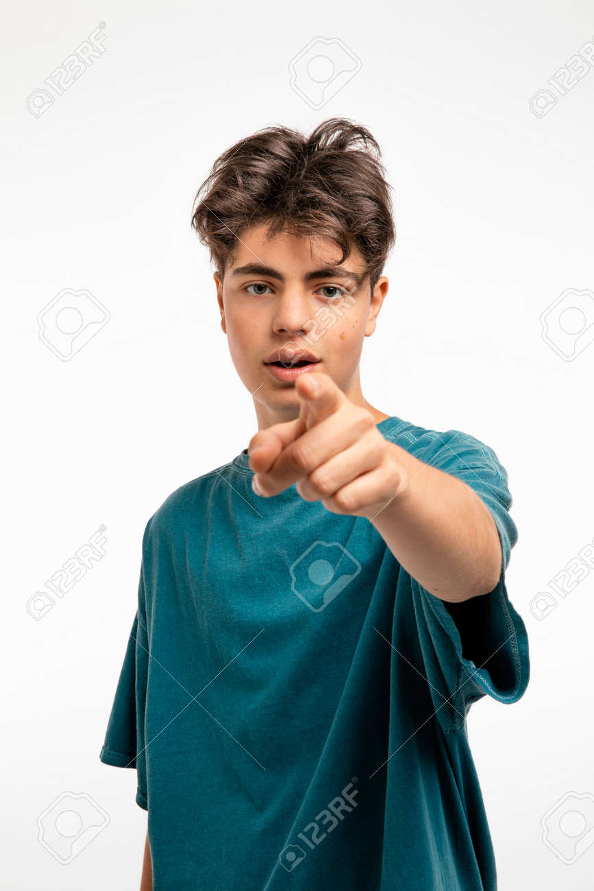 Portrait of teenager on white background in studio. The boy is standing and pointing with his finger at you who are standing in front of him - 170379907 Portrait of teenager on white background in studio. The boy is standing and pointing with his finger at you who are standing in front of him - 170379907