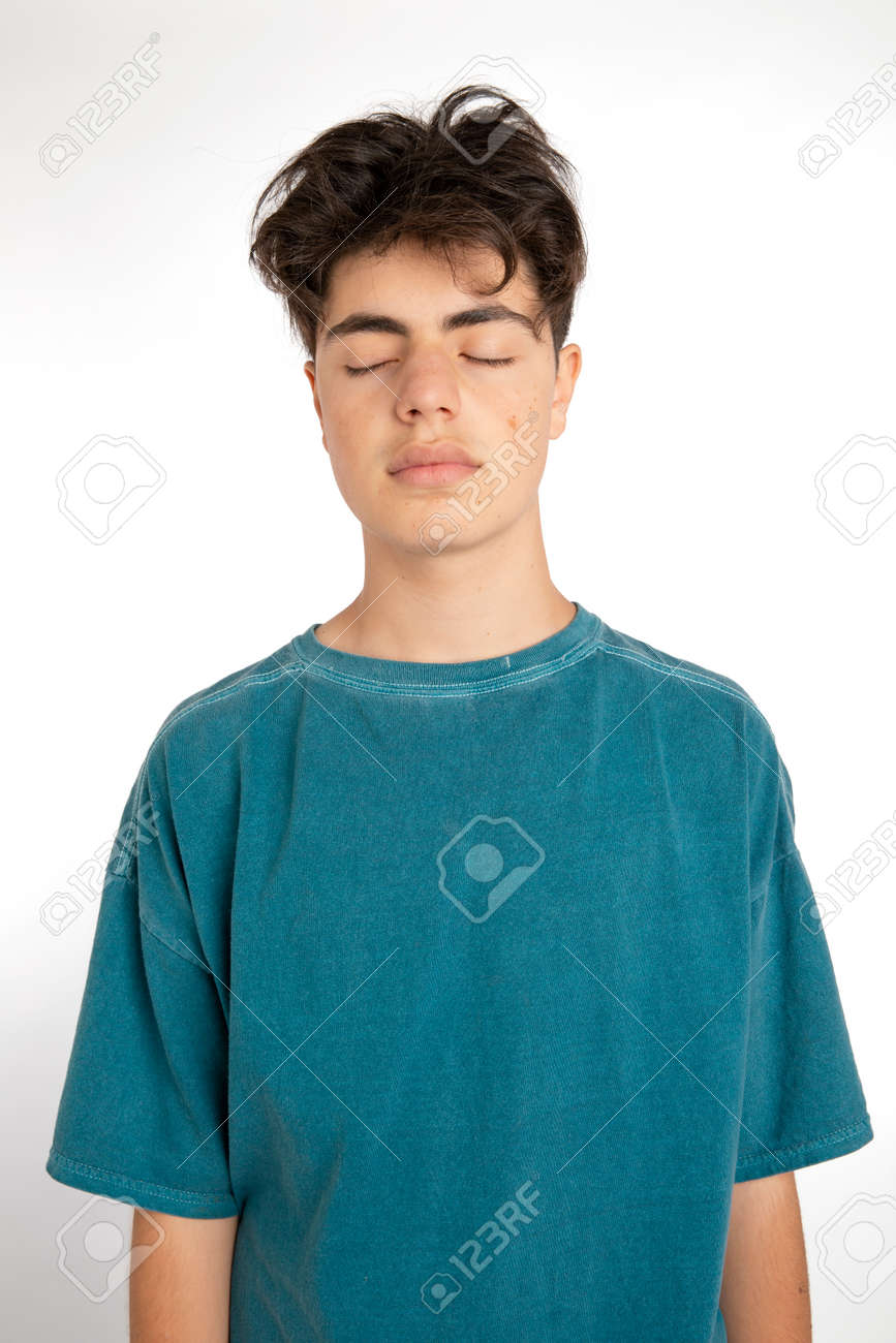 Portrait of teenager on white background in studio. The boy is standing and has his eyes closed. He could dream, think or imagine something beautiful about his future - 170379921 Portrait of teenager on white background in studio. The boy is standing and has his eyes closed. He could dream, think or imagine something beautiful about his future - 170379921