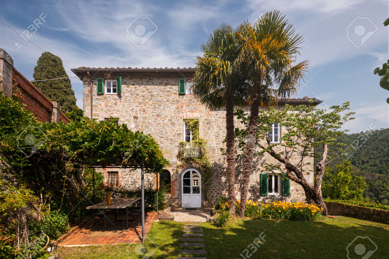 Beautiful Italian farmhouse in Tuscany surrounded by nature with a large garden. The season is summer and the sun is shining. - 171317496 Beautiful Italian farmhouse in Tuscany surrounded by nature with a large garden. The season is summer and the sun is shining. - 171317496