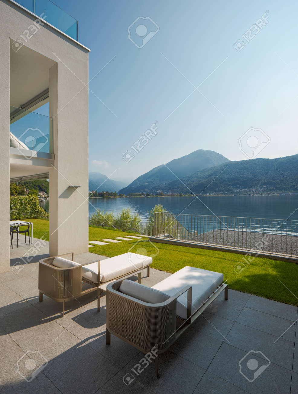 Detail of private terrace overlooking Lake Ceresio in Switzerland. Two deck chairs in the foreground. it's a sunny day and it's midsummer - 171413318 Detail of private terrace overlooking Lake Ceresio in Switzerland. Two deck chairs in the foreground. it's a sunny day and it's midsummer - 171413318