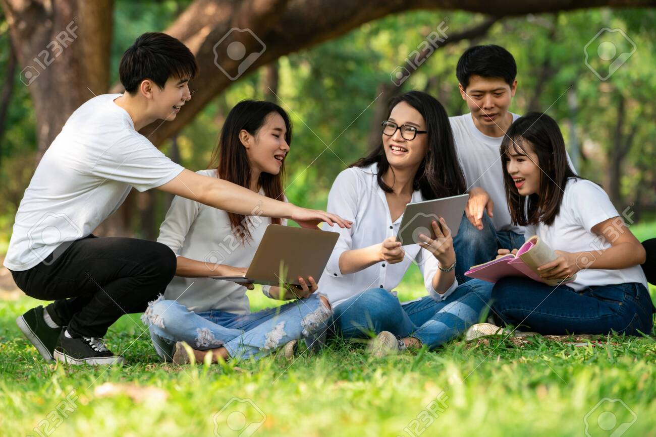 Team of young students studying in a group project in the park of university or school. Happy learning, community teamwork and youth friendship concept. - 134515359 Team of young students studying in a group project in the park of university or school. Happy learning, community teamwork and youth friendship concept. - 134515359