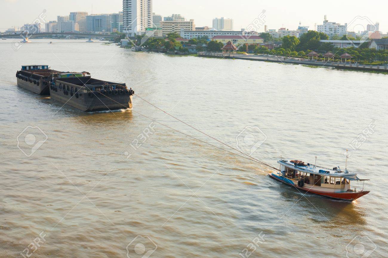 小さなタグボートはバンコク タイのチャオプラヤ川まで大きいはしけを引っ張る の写真素材 画像素材 Image
