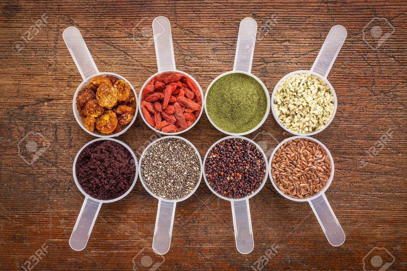 スーパー フード抽象 ウィート グラス アサイベリー 剛ベリー 亜麻の種子 チアシード ゴールデンベリー 大麻種子 キノア穀物 無作法な木に対してスクープを測定の平面図 の写真素材 画像素材 Image