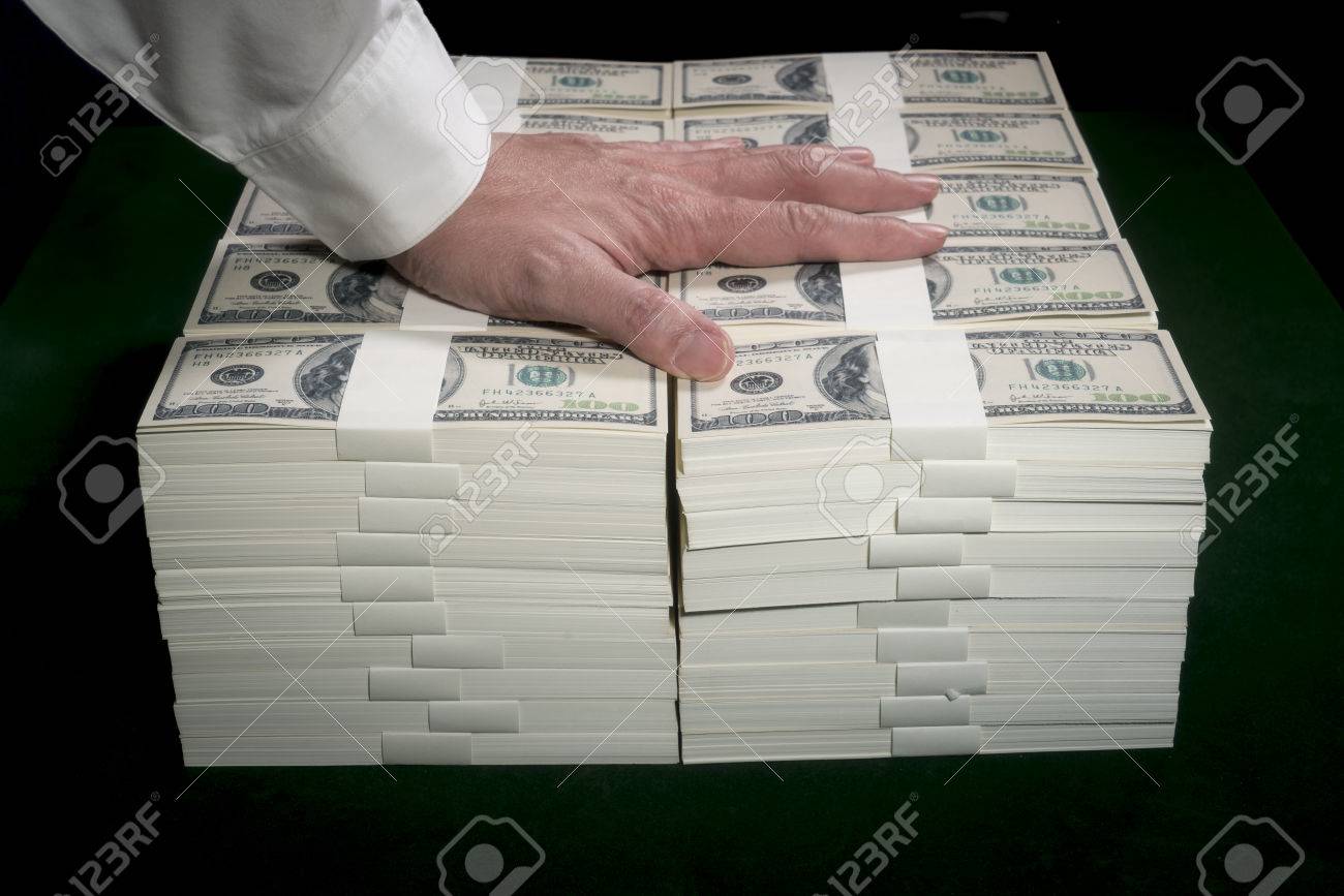Stacks of one million US dollars in hundred dollar banknotes on green table. - 72779869