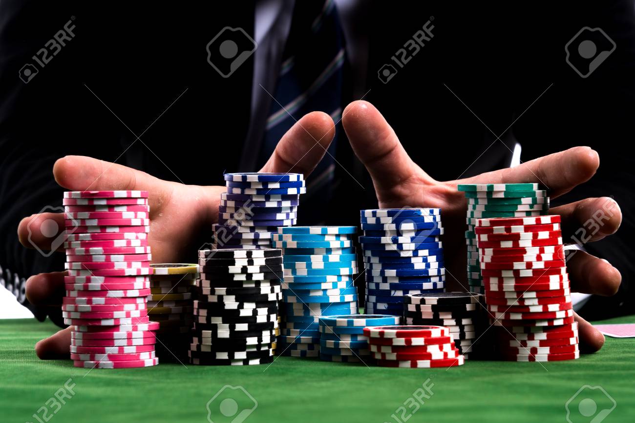 78028730-gambler-man-hands-pushing-large-stack-of-colored-poker-chips-across-gaming-table-for-betting.jpg