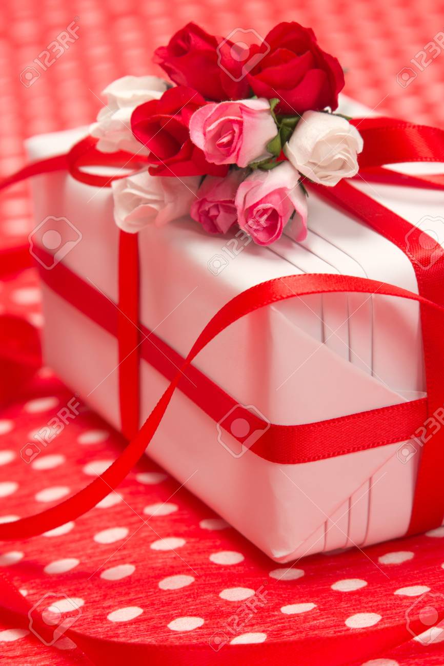 white gift box with red bow and paper flowers on red background paper flower gift box