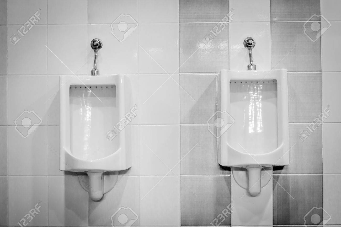 Urinarios En El Bano En Los Azulejos De La Pared De Fondo Fotos