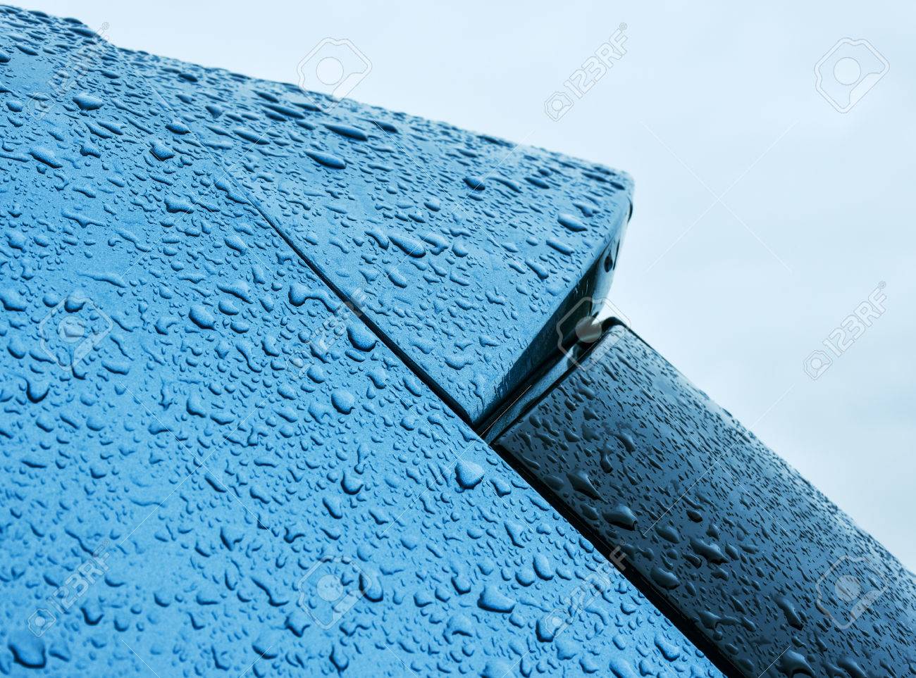雨青のメタリック塗装車の上に保持されます の写真素材 画像素材 Image