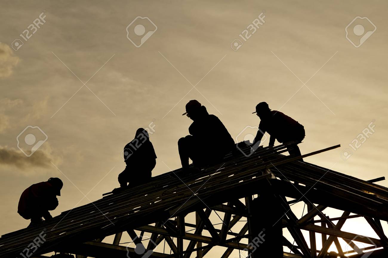 Contractor in Silhouette working on a Roof Top with Sky in background - 84076692 Contractor in Silhouette working on a Roof Top with Sky in background - 84076692