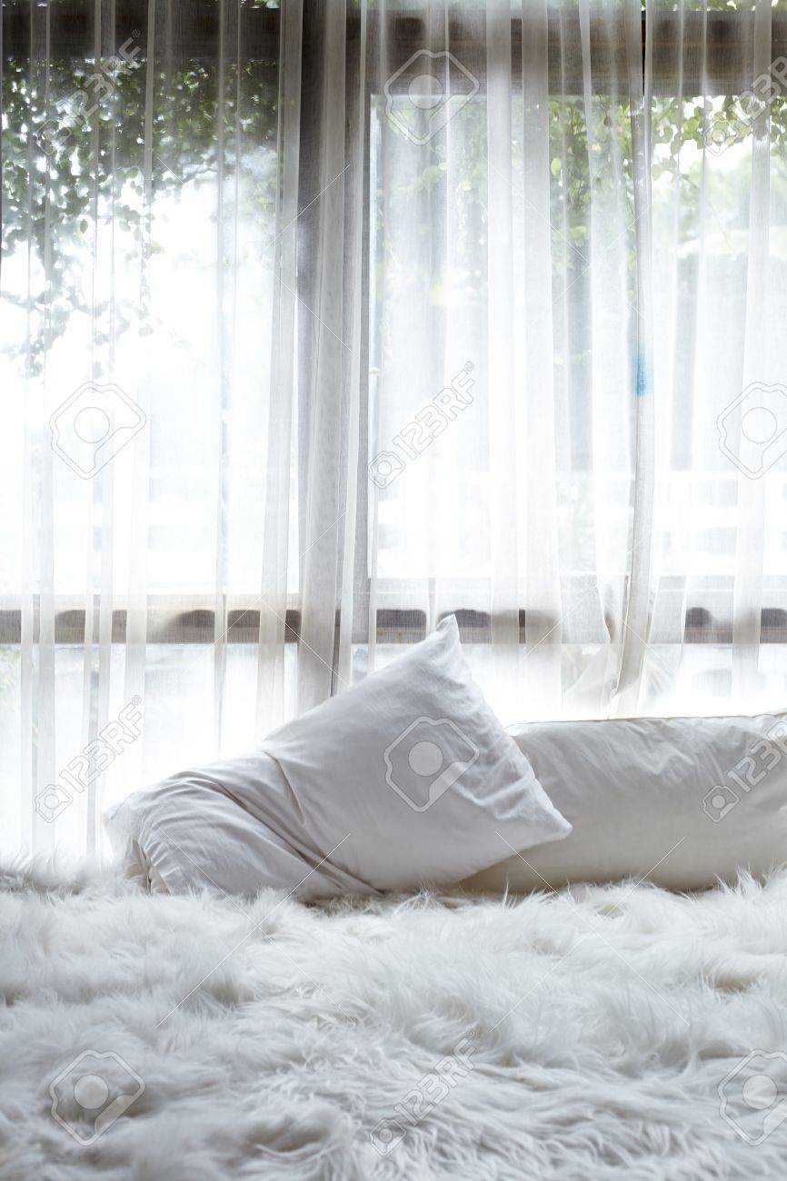 abstraktes weißes schlafzimmer mit weißem vorhang auf fenster